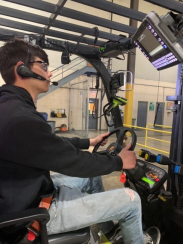 Person driving lift truck with voice headset