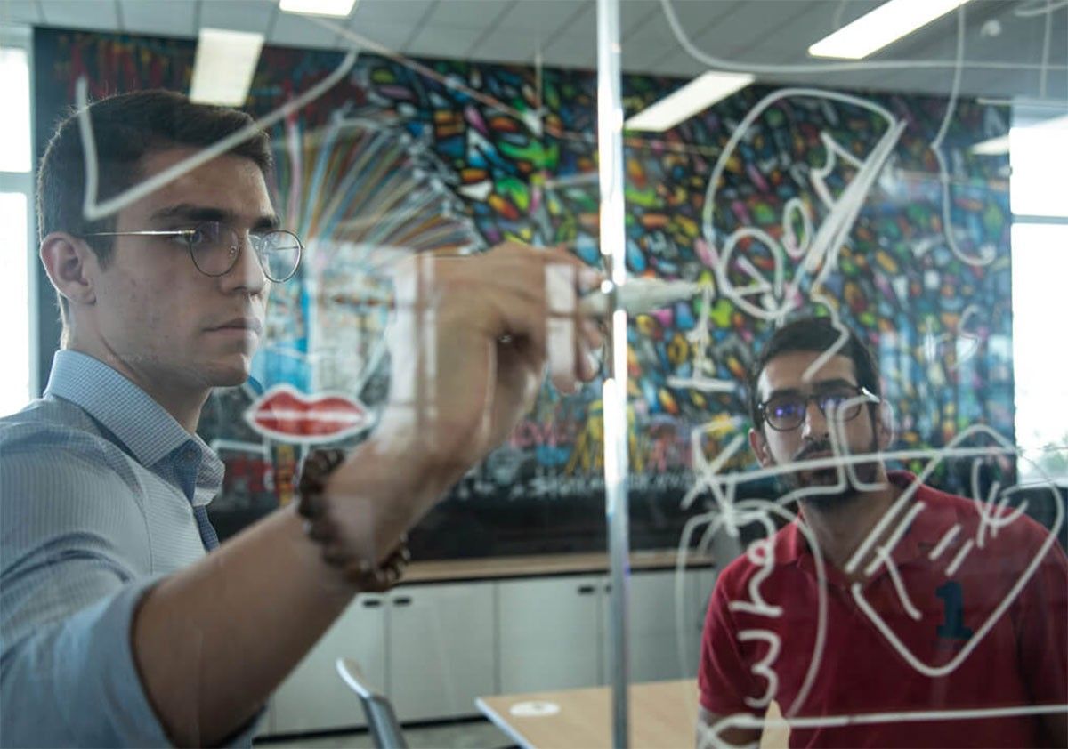 Person writing on glass board