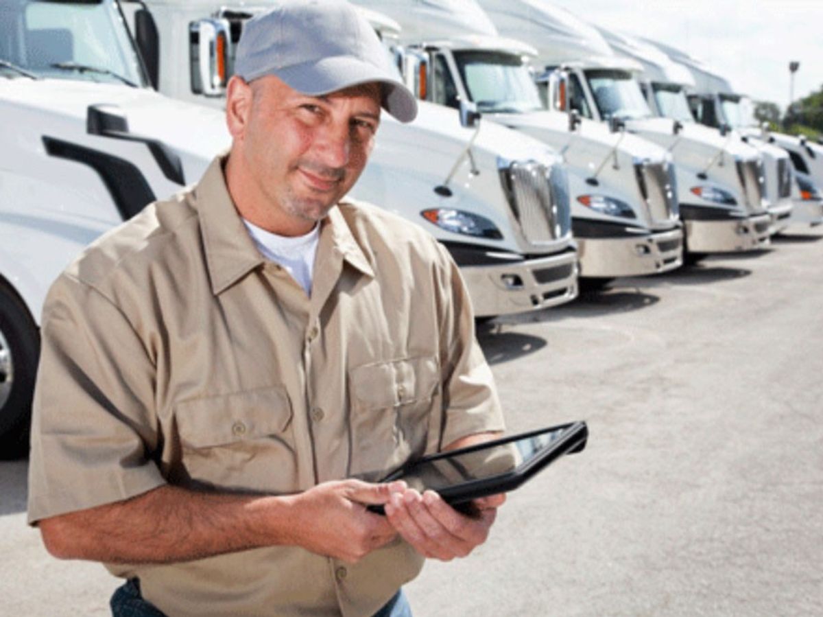 Truck driver in front of line of trucks